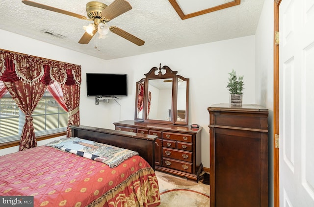 bedroom featuring visible vents, a ceiling fan, light carpet, and a textured ceiling