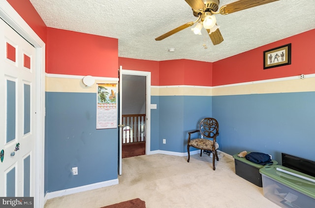 bedroom with carpet flooring, a textured ceiling, baseboards, and a ceiling fan