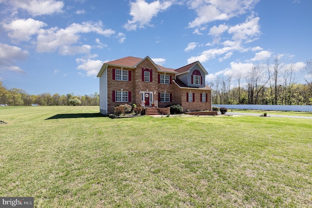 view of front of house with a front yard and brick siding
