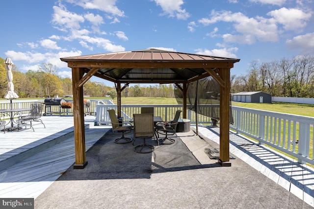 view of patio / terrace featuring an outbuilding, a gazebo, a deck, and outdoor dining area