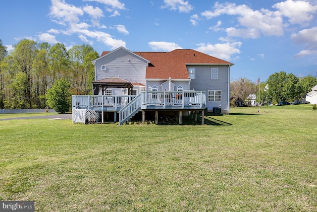 rear view of property with a gazebo, cooling unit, a wooden deck, and a lawn
