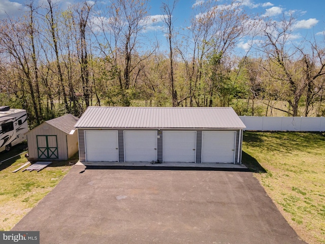 detached garage featuring fence