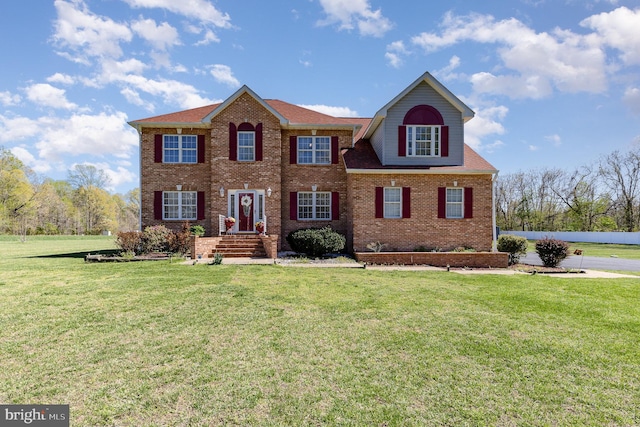 view of front of property featuring brick siding and a front yard