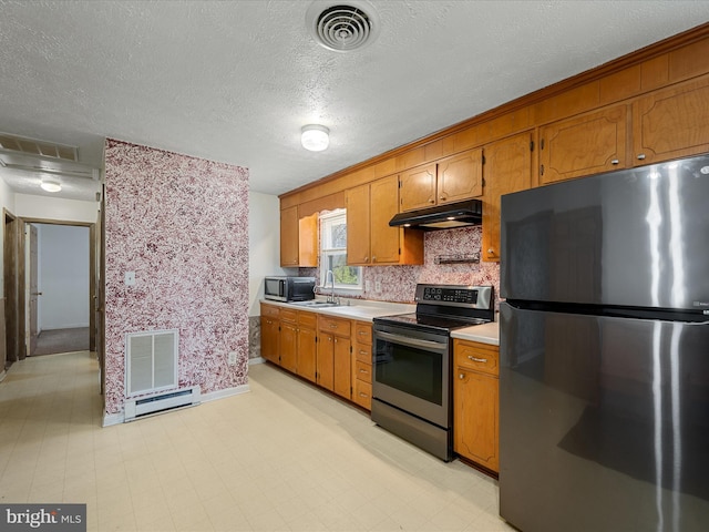 kitchen featuring stainless steel electric stove, under cabinet range hood, visible vents, and freestanding refrigerator
