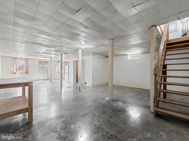 basement featuring a wealth of natural light and stairs