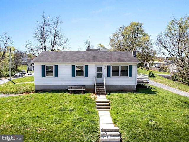 view of front of home with entry steps, a front lawn, and a chimney