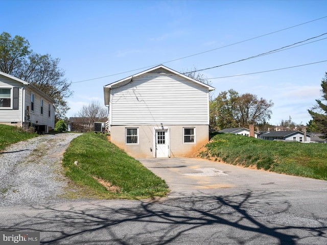 back of property with driveway and central AC unit