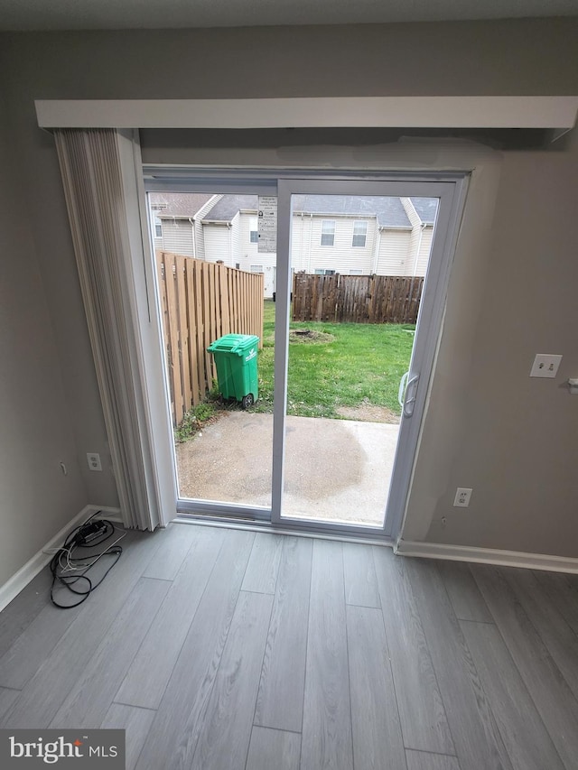 doorway to outside with wood finished floors, baseboards, and plenty of natural light