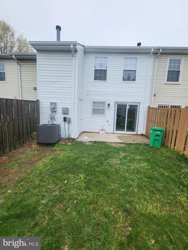 rear view of property with central AC, fence, a patio, and a lawn