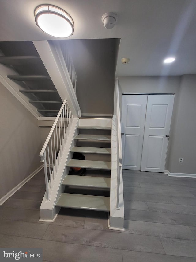 staircase with recessed lighting, baseboards, and wood finished floors