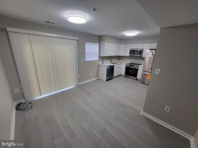 kitchen with visible vents, baseboards, a sink, light countertops, and appliances with stainless steel finishes