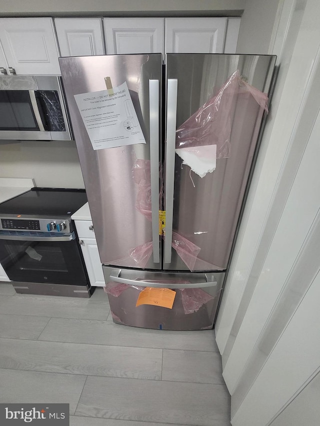 room details featuring white cabinets and appliances with stainless steel finishes