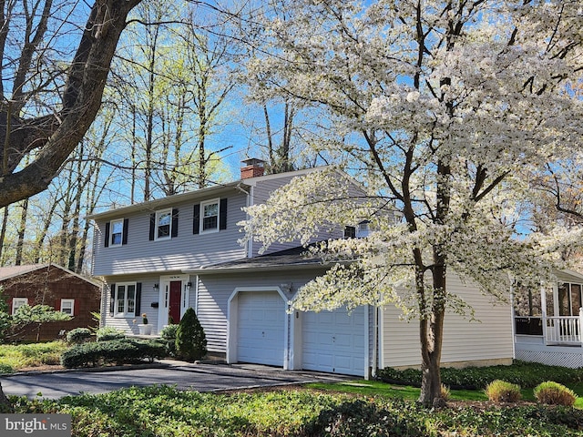 view of front of property with a chimney and aphalt driveway