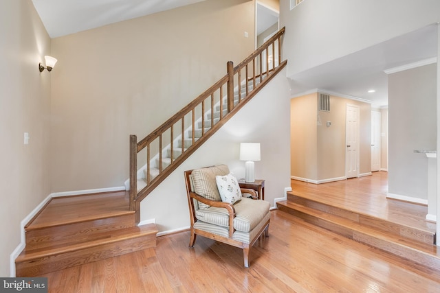 stairs with baseboards, visible vents, and wood finished floors