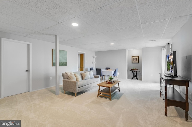 carpeted living room featuring a drop ceiling and recessed lighting