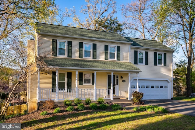 traditional-style home with a porch, a garage, a shingled roof, aphalt driveway, and fence
