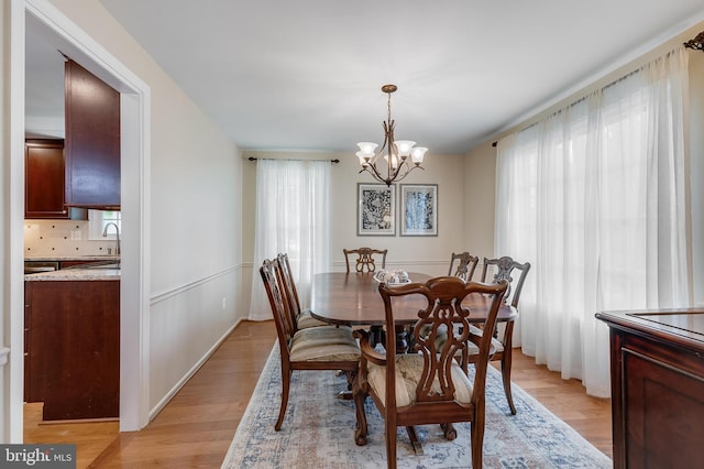dining area featuring a wealth of natural light, a chandelier, and light wood-type flooring