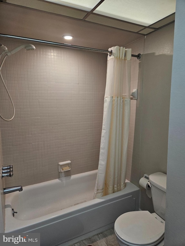 bathroom with toilet and shower / bath combination with curtain