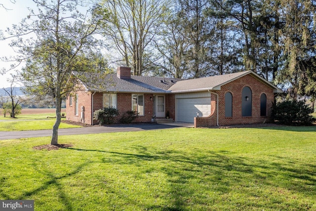 ranch-style house with a chimney, driveway, a front yard, brick siding, and a garage