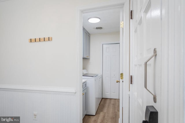 laundry area featuring cabinet space, visible vents, light wood-type flooring, and washer and dryer