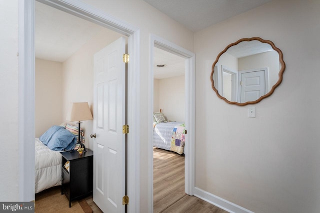 hallway featuring wood finished floors and baseboards