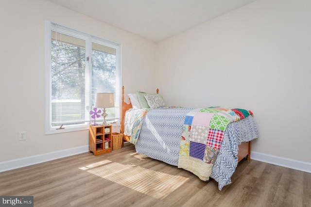 bedroom featuring baseboards and wood finished floors