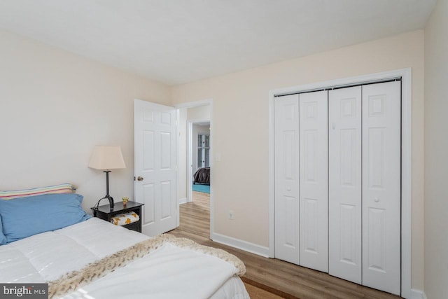 bedroom with a closet, baseboards, and wood finished floors