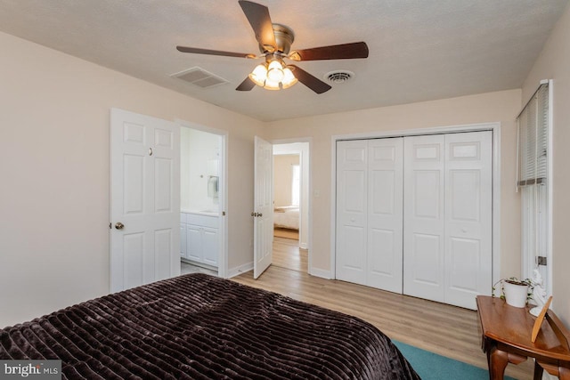 bedroom featuring visible vents, light wood finished floors, a closet, and a ceiling fan
