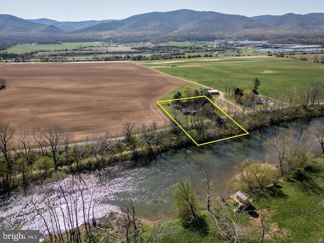 drone / aerial view with a water and mountain view and a rural view