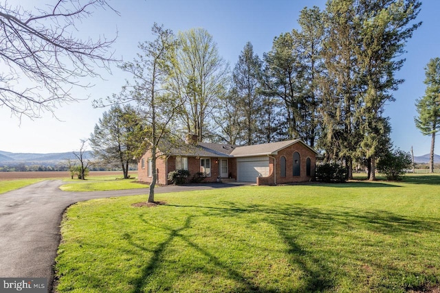 view of front of home with brick siding, a front yard, a garage, and aphalt driveway