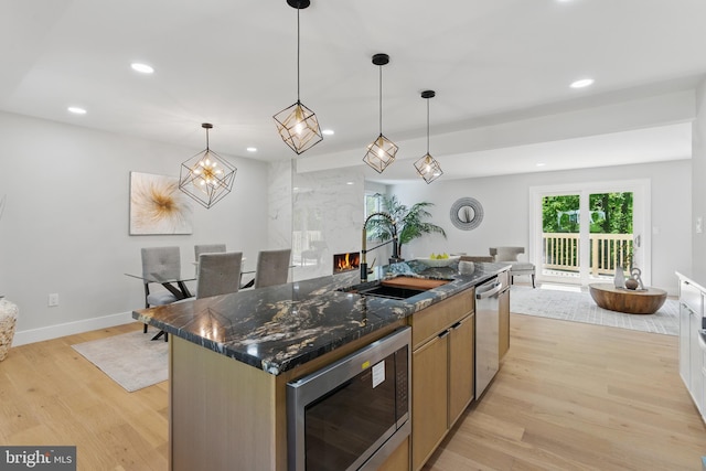 4838 Randolph Dr, Annandale, VA 22003 - kitchen featuring a center island with sink, a sink, stainless steel appliances, recessed lighting, and light wood-style flooring