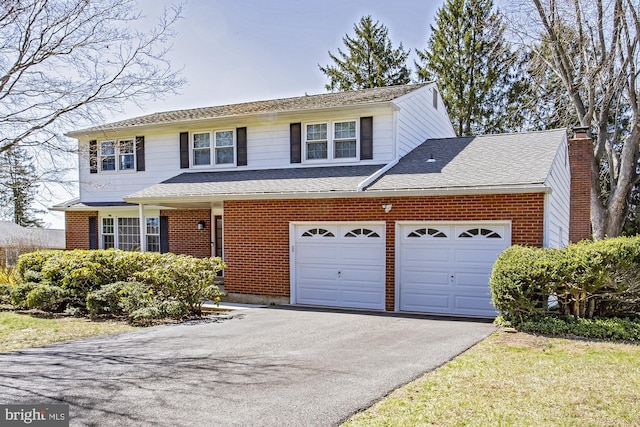 traditional-style house with brick siding, a chimney, and aphalt driveway