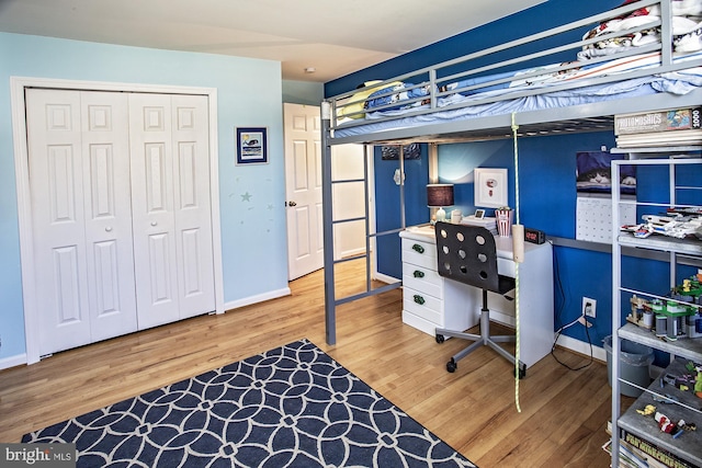 bedroom with a closet, baseboards, and wood finished floors