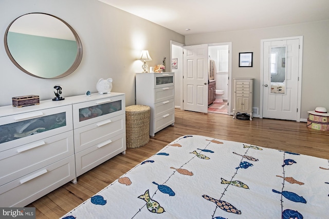 bedroom featuring ensuite bathroom and light wood-style floors