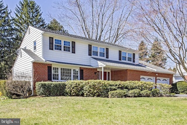 traditional-style house with roof with shingles, brick siding, an attached garage, and a front lawn
