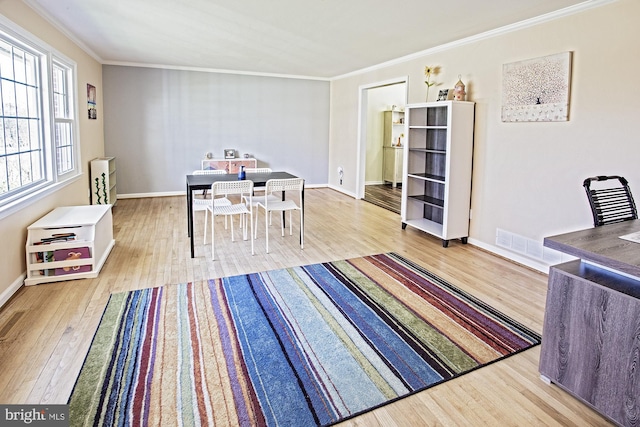dining area with crown molding, visible vents, baseboards, and wood finished floors