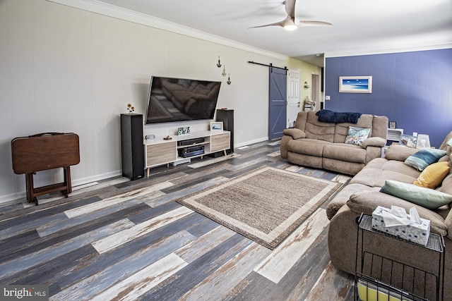 living room featuring baseboards, a barn door, a ceiling fan, crown molding, and dark wood-type flooring