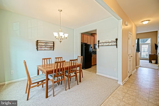 dining area featuring a chandelier, light carpet, and baseboards