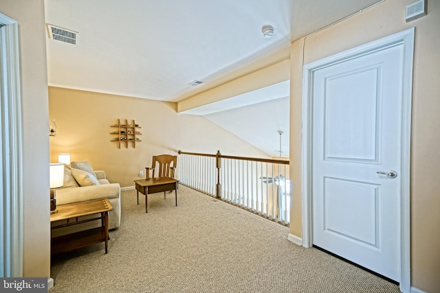 living area featuring carpet, vaulted ceiling with beams, and visible vents