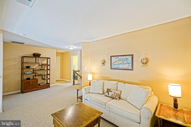carpeted living area featuring visible vents and baseboards