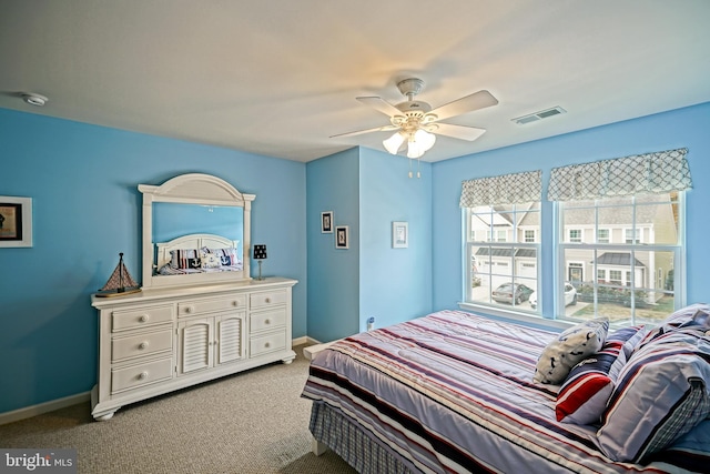 carpeted bedroom with baseboards, a ceiling fan, and visible vents