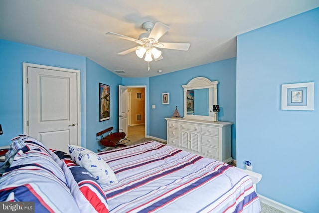 carpeted bedroom featuring visible vents, baseboards, and a ceiling fan