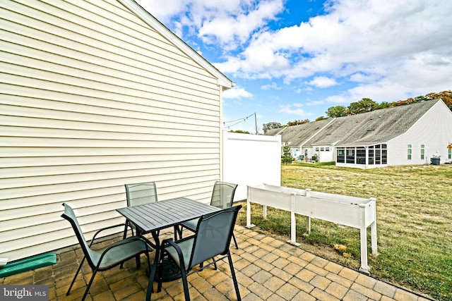 view of patio featuring outdoor dining space and a sunroom