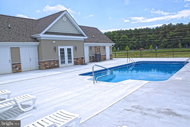view of pool with a patio area, fence, french doors, a fenced in pool, and central AC unit