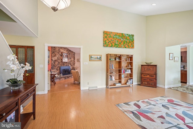 205 S Lehigh Rd, Glassboro, NJ 08028 - interior space with baseboards, a wood stove, wood finished floors, and a towering ceiling