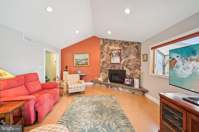 205 S Lehigh Rd, Glassboro, NJ 08028 - living area with a stone fireplace, visible vents, vaulted ceiling, and light wood-style floors