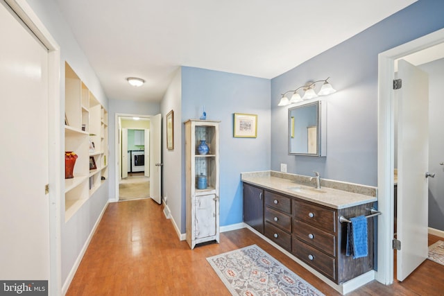 205 S Lehigh Rd, Glassboro, NJ 08028 - bathroom featuring baseboards, wood finished floors, built in shelves, and vanity