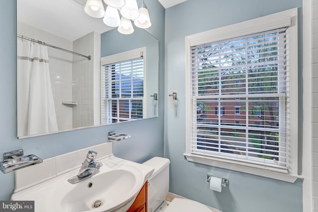 bathroom featuring a chandelier, toilet, vanity, and a shower with shower curtain
