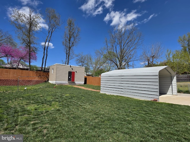 view of yard with entry steps, an outbuilding, and fence