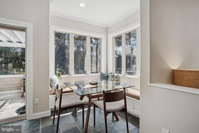 dining area with baseboards, a wealth of natural light, ornamental molding, and stone finish flooring